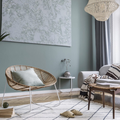Boho interior design of living room with sofa and rattan armcha